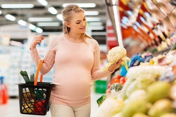 Беременная выбирает продукты